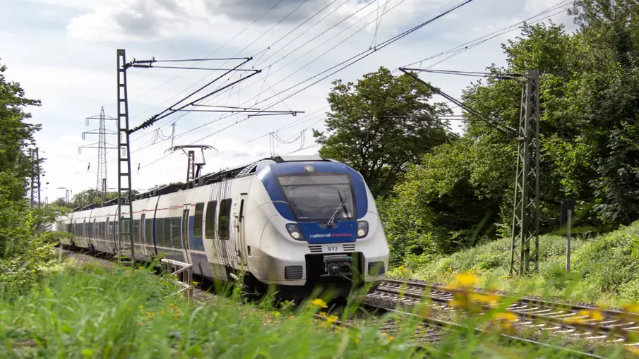 Ein Zug von National Express fährt durch eine grüne Landschaft