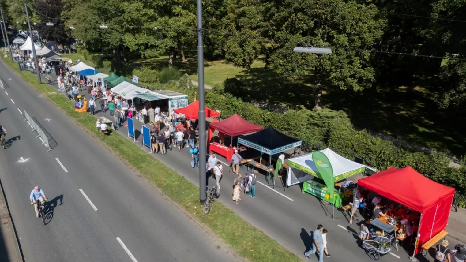 Eine Straße mit Infoständen und Fußgängern