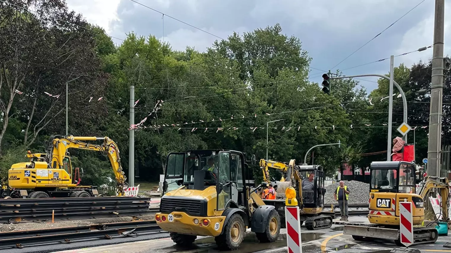 Neubau Haltestelle Brückelstraße: Blick auf die Baustelle mit mehreren Bauarbeitern und Baumaschinen