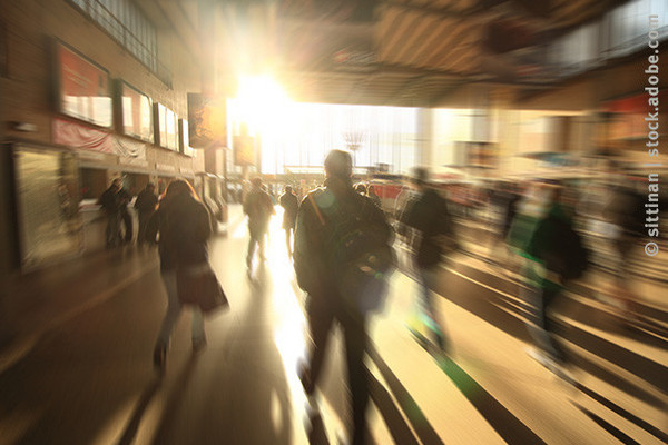 Bild mit Bewegungsunschärfe von Menschen in einer Bahnhofsvorhalle