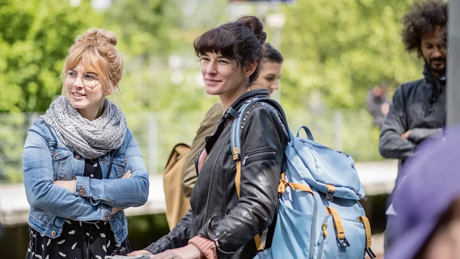 a group of young people standing on a railway platform