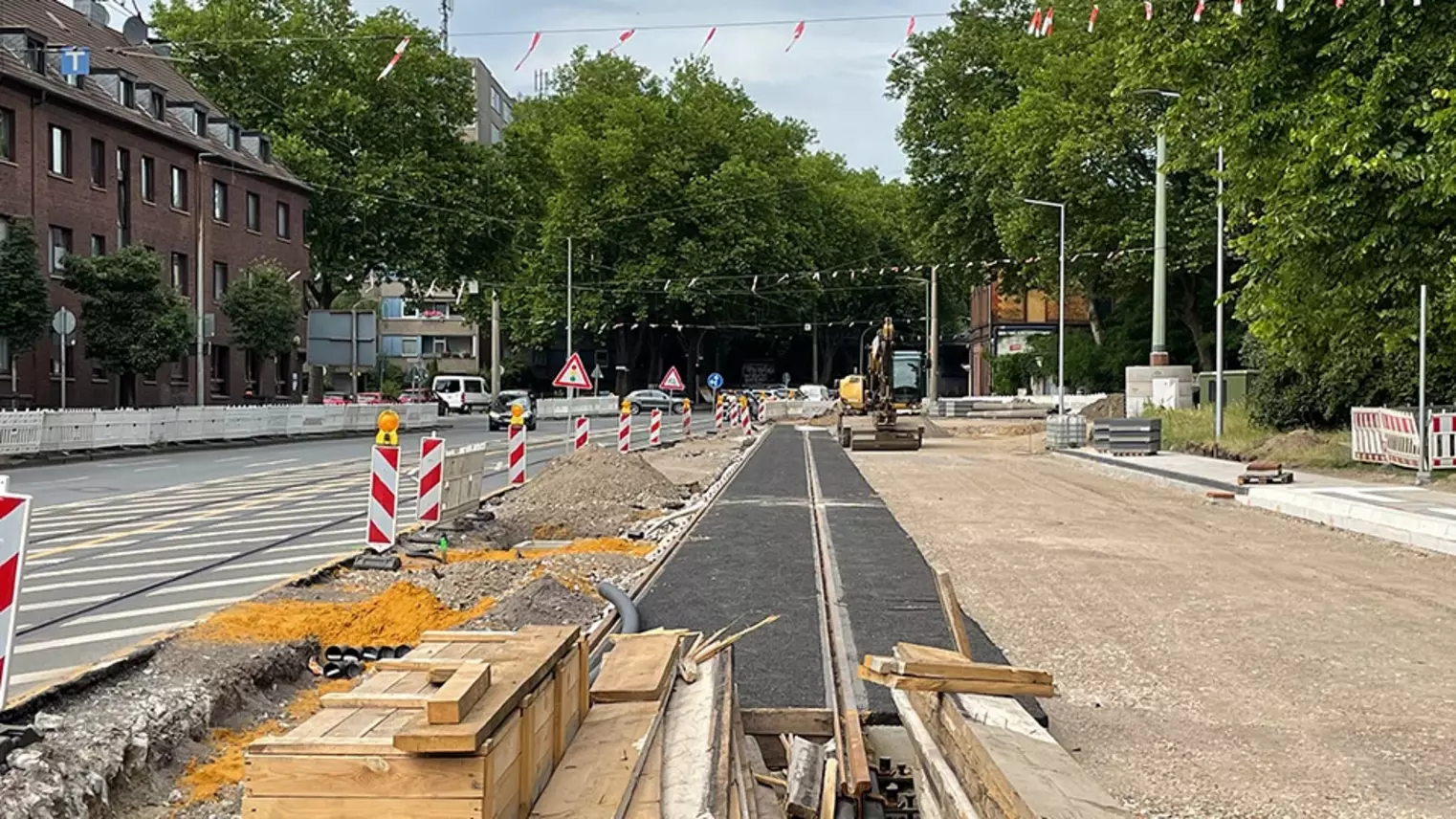 Neubau Haltestelle Brückelstraße: der alte Asphalt ist teilweise abgetragen, im Hintergrund ist eine Baumaschine zu sehen