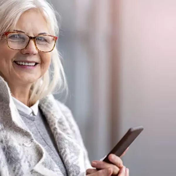 An old lady watches her phone