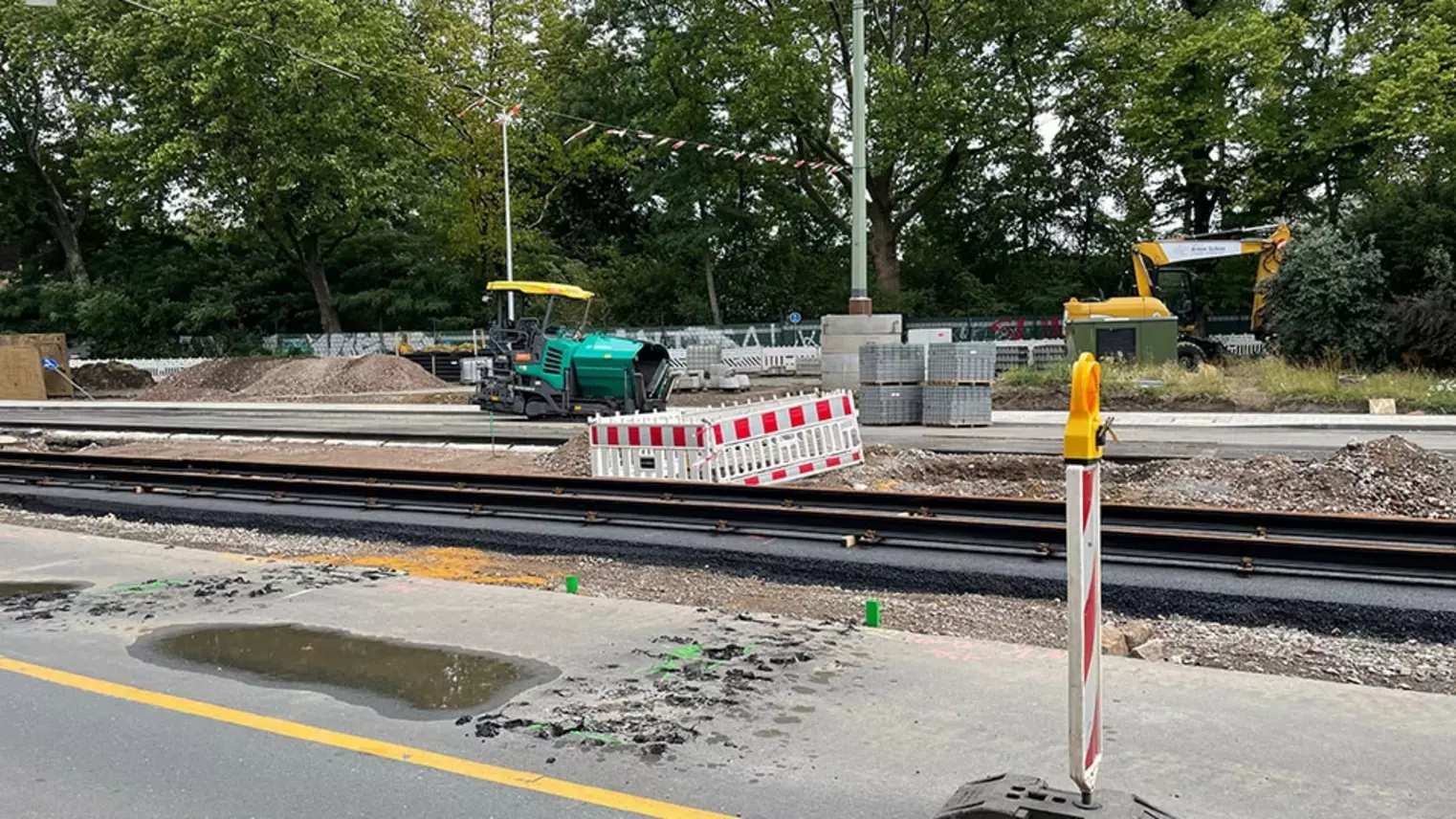 Neubau Haltestelle Brückelstraße: Blick auf die Baustelle, auf neuem Asphalt sind neue Gleise verlegt