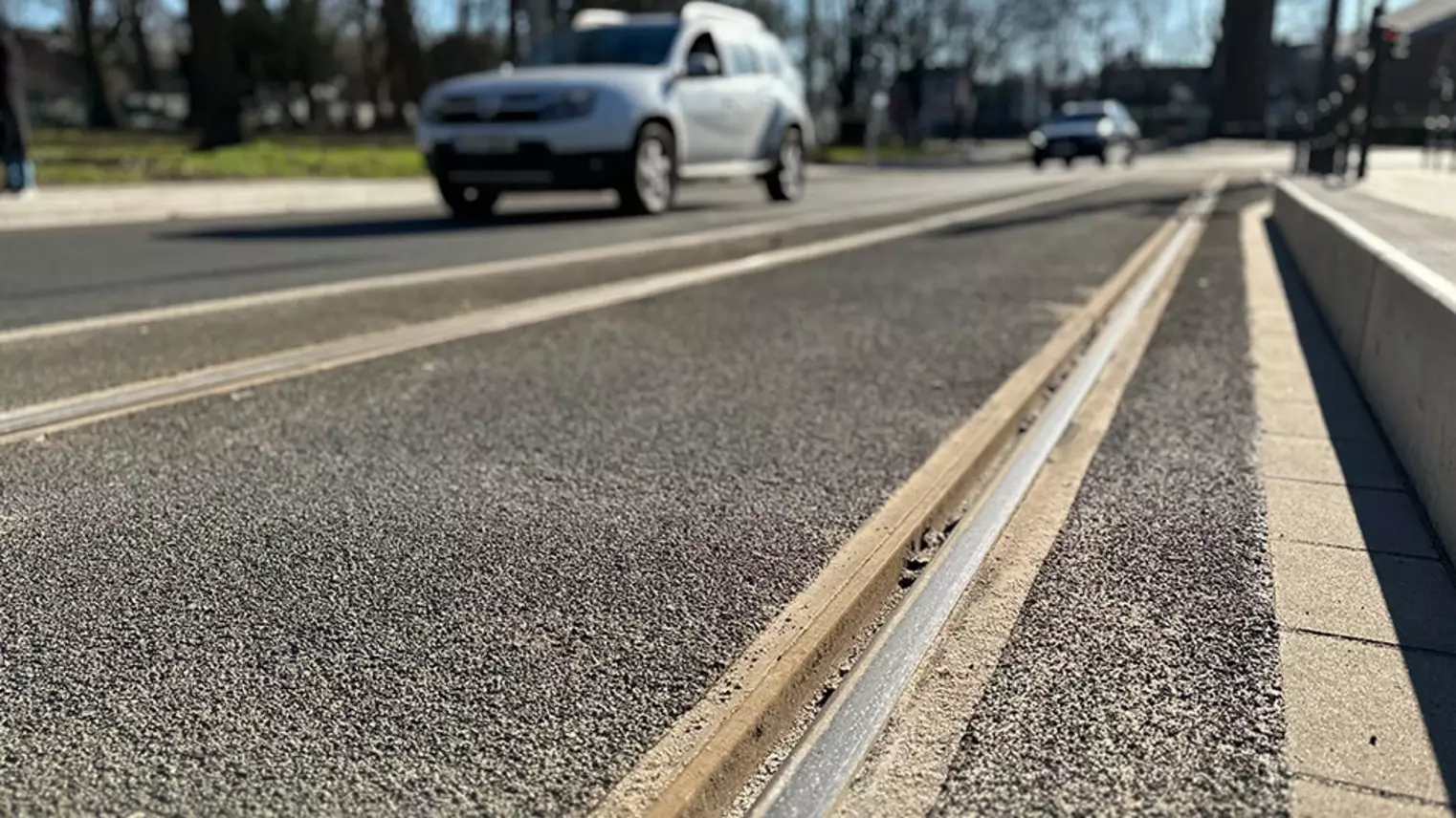 Neubau Haltestelle Brückelstraße: Detailaufnahme der neuen Gleise, im Hintergrund sind verschwommen Autos zu sehen