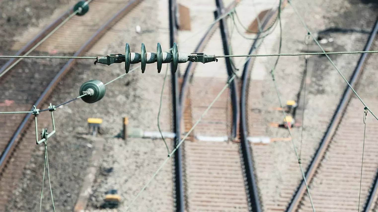 Stromleitungen vor Gleisen im Hintergrund