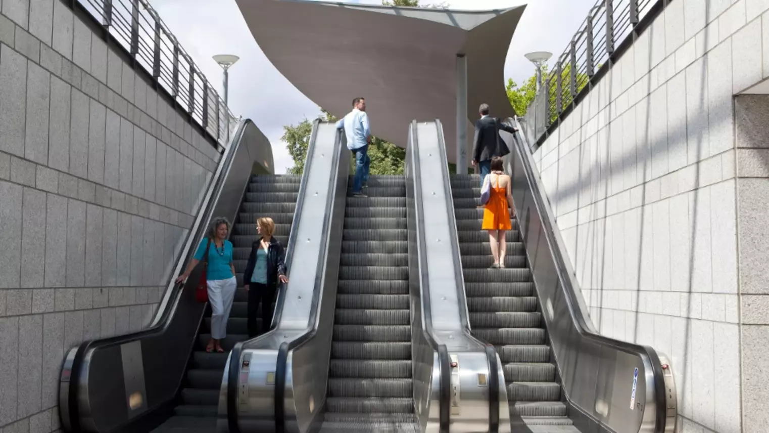 Mehrere Fahrgäste nutzen am Bahnhof die Rolltreppen