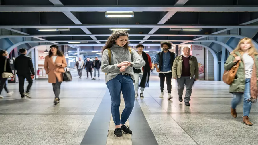 Mehrere Personen laufen durch einen Bahnhof