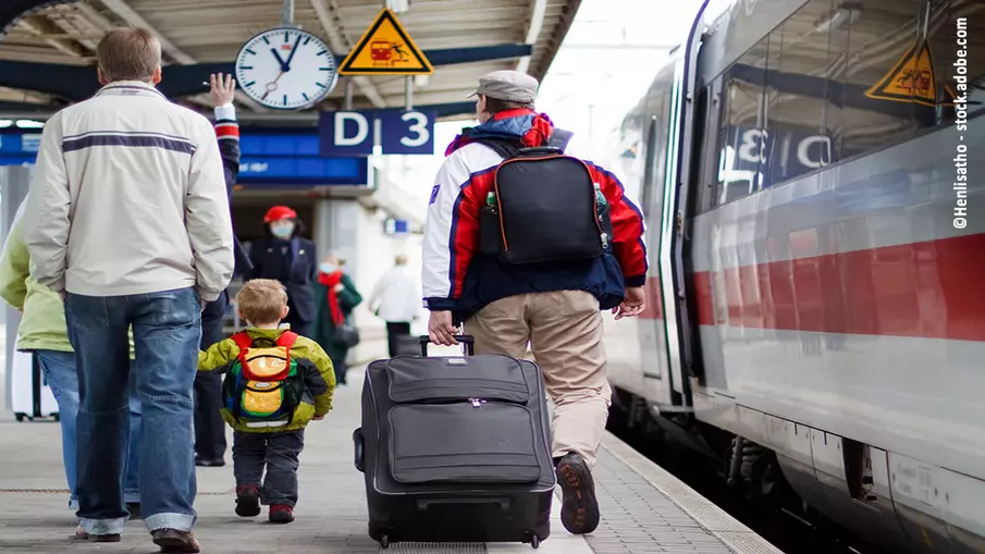 Menschen, die am Bahnsteig in Richtung Zug laufen