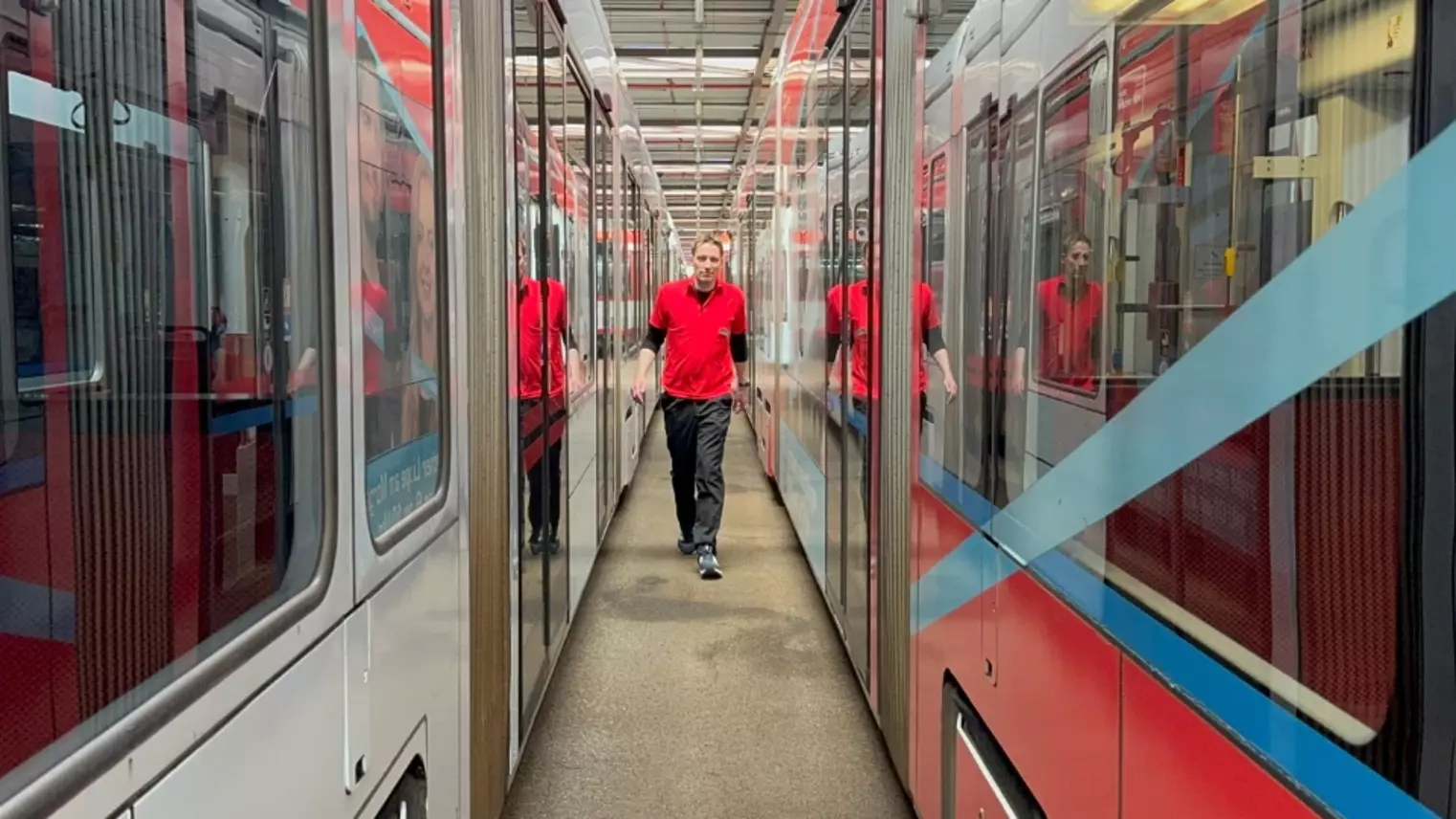 Robert Nieberg läuft zwischen zwei Straßenbahnen hin und her 