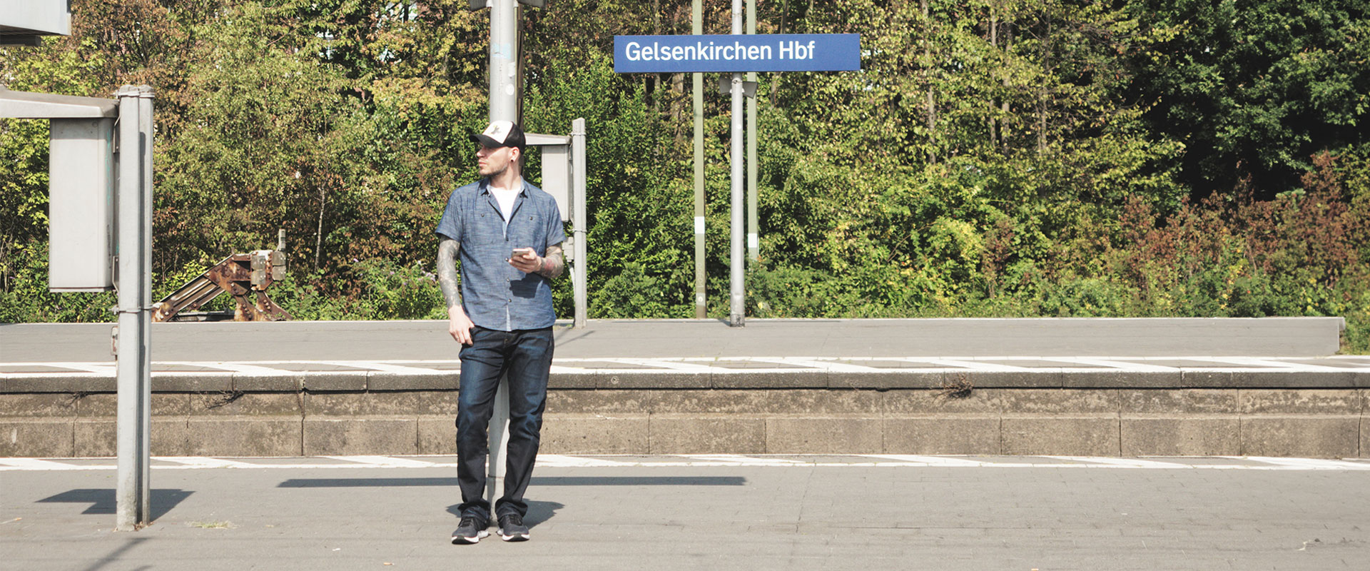 Ein Mann mit Smartphone steht am Gelsenkirchener Hauptbahnhof am Bahnsteig