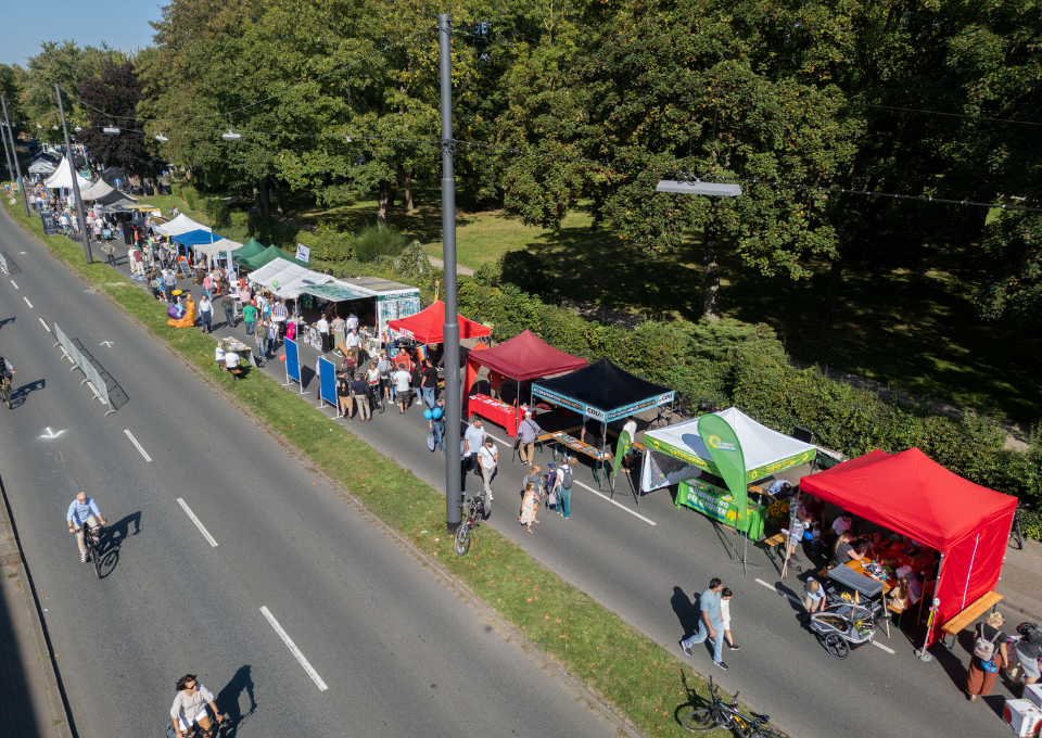 Eine Straße mit Infoständen und Fußgängern