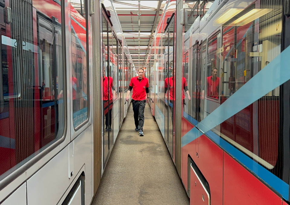 Robert Nieberg läuft zwischen zwei Straßenbahnen hin und her 