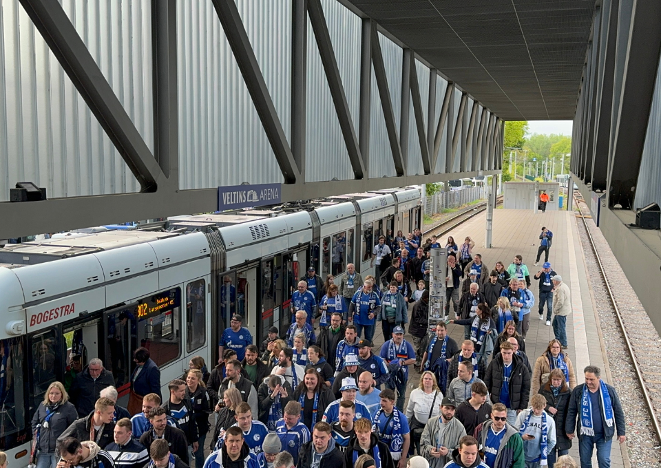 Fußballfans des FC Schalke 04 strömen aus den Straßenbahnen in Richtung Arena